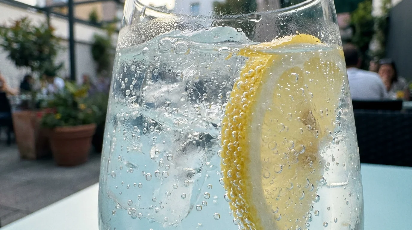 A close-up of carbonated water with bubbles and ice, illustrating the trapped gas in fizzy drinks.