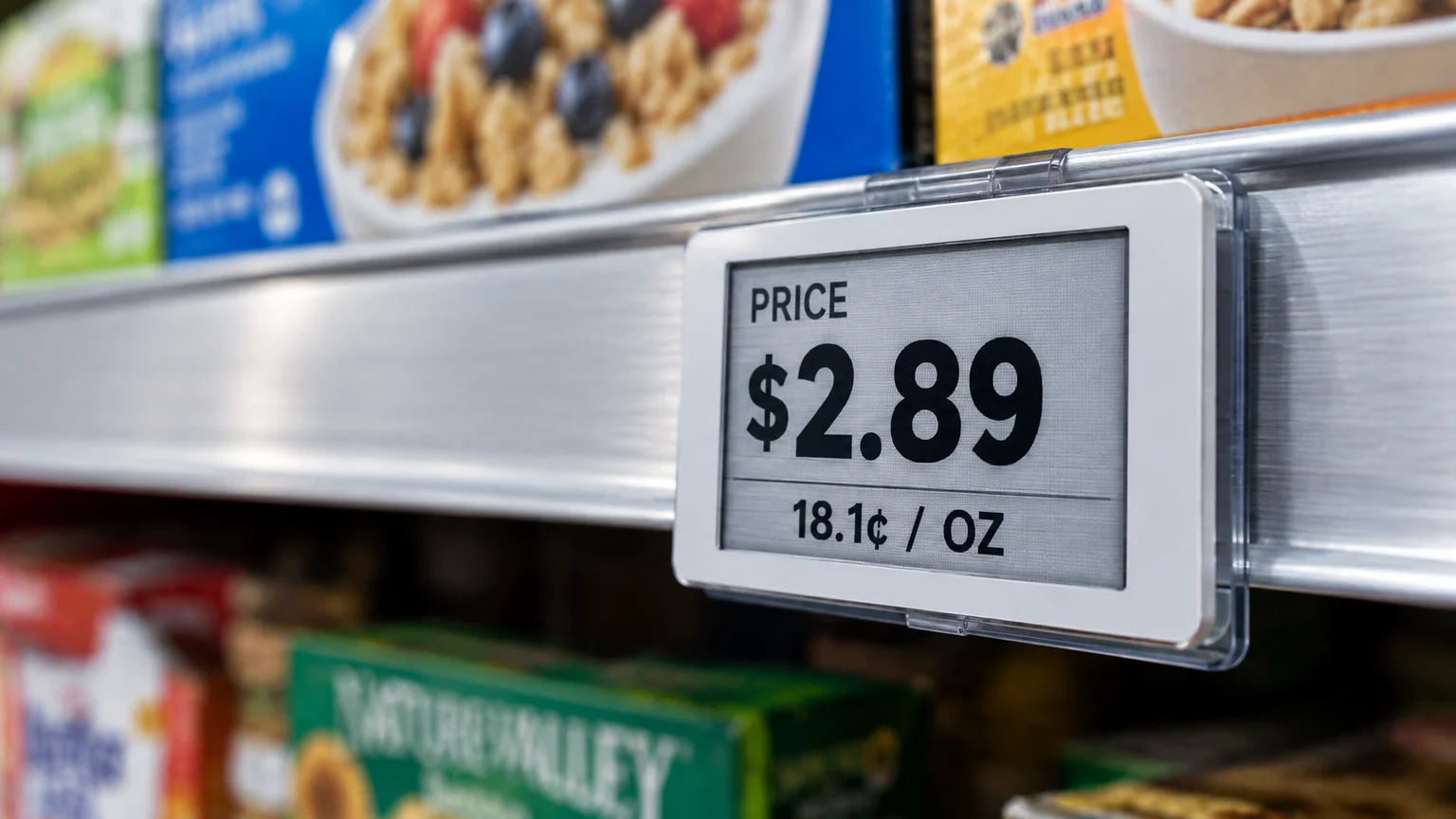 Digital electronic price tag on a grocery store shelf showing a price of $2.89 and a unit price of 18.1 cents per ounce.